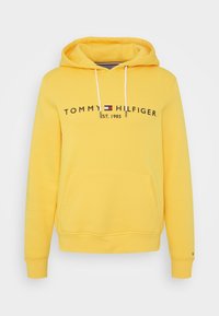 Sudadera con capucha amarilla, mezcla de algodón, con bolsillo delantero, capucha con cordón y logo impreso "TOMMY HILFIGER EST. 1985" en negro.