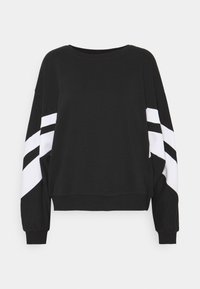 Sudadera negra con cuello redondo y mangas largas. Presenta rayas diagonales en blanco y negro en las mangas. Tejido suave, corte relajado.