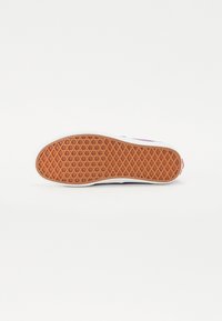 Shoe sole with a textured rubber surface, featuring a honeycomb pattern in orange and white borders, ensuring grip and durability.