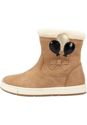 Botas de tobillo de ante en color trigo con un cuello de piel sintética, que cuentan con acentos de globos negros y un detalle de lazo. Suela de goma para mayor tracción.