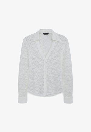 Blusa bianca in pizzo con colletto, chiusura a bottoni e maniche lunghe. Il tessuto struttura presenta un motivo floreale e una vestibilità comoda.