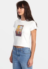 White cropped t-shirt with a colorful graphic print centered on the front. Short sleeves and a soft, textured fabric.