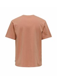 Korte mouwen t-shirt in zacht perzik katoen, met een eenvoudige ronde hals, een ontspannen pasvorm en geen zichtbare patronen of graphics op de achterkant.