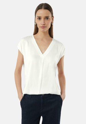 Weißes V-Ausschnitt-Shirt mit kurzen Ärmeln, glatte Textur, lockere Passform, kombiniert mit dunkler Denim. Schlichtes und minimalistisches Design.
