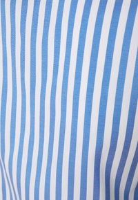 Tecido listrado azul e branco com linhas verticais, apresentando cores alternadas que criam uma textura suave e uma aparência leve.