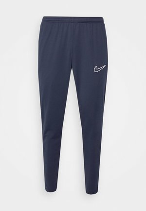 Marine sportbroeken met elastische tailleband, taps toelopende benen, gemaakt van een gladde stof, met een wit Nike-logo aan de linkerkant.
