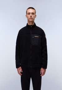 Schwarze Fleecejacke mit hohem Kragen, Reißverschluss und Brusttasche. Enthält eine strukturierte Oberfläche und ein einfarbiges Design.