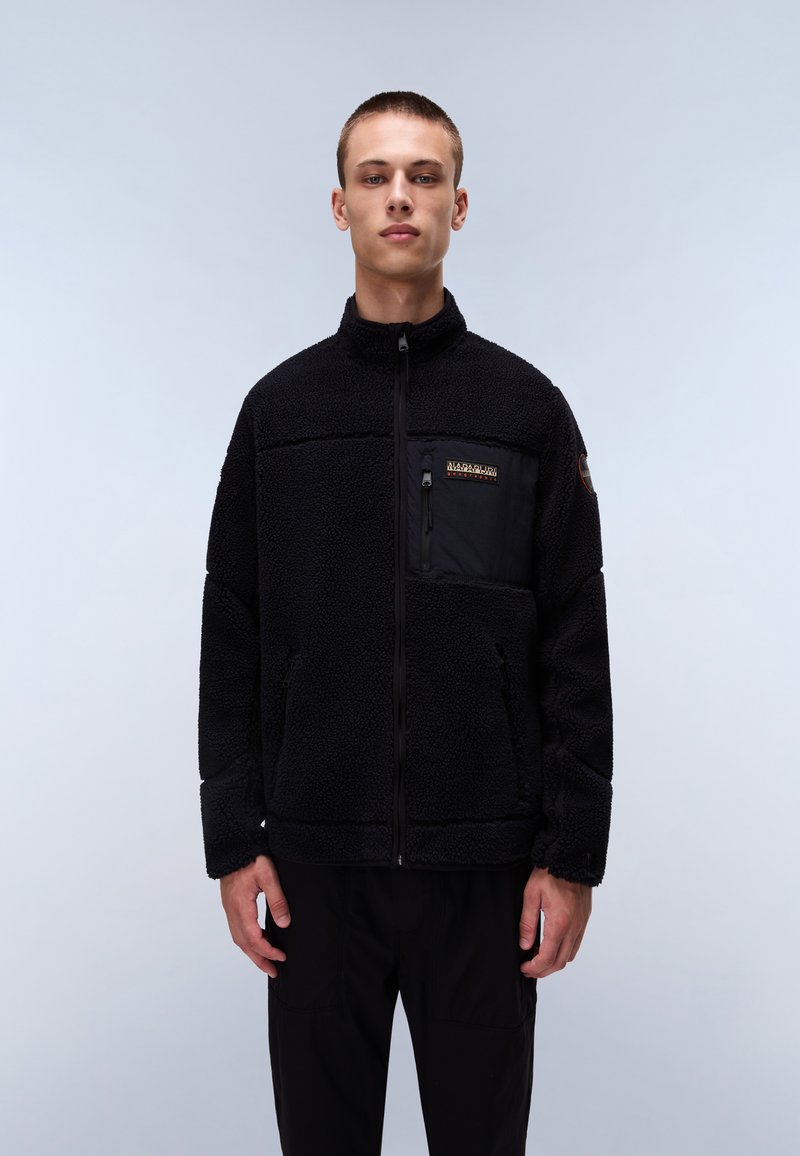 Schwarze Fleecejacke mit hohem Kragen, Reißverschluss und Brusttasche. Enthält eine strukturierte Oberfläche und ein einfarbiges Design.