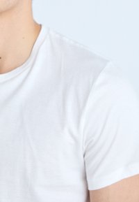 White cotton t-shirt with a crew neck and short sleeves, featuring a smooth texture and a classic, fitted shape.