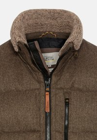 Brun jakke med fiskebensmønster og fleece-foring langs kraven. Har sorte lynlåse, lædertræk og en subtil tekstur.