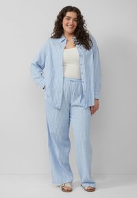 Lichtblauw gestreepte buttons-up shirt gecombineerd met bijpassende loszittende broeken, gemaakt van zachte stof met een elastische tailleband.