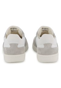 Λευκά και γκρι αθλητικά παπούτσια με σχεδιασμό από σουέτ και δίχτυ, με υφή στο πίσω μέρος και ελαστικές σόλες. Απλό, χαμηλού προφίλ σχήμα.