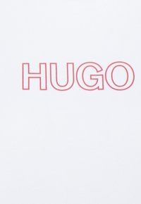 Tekst "HUGO" w pogrubionym czerwonym konturze, wyśrodkowany na gładkim białym tle, prezentujący nowoczesny i czysty styl czcionki.