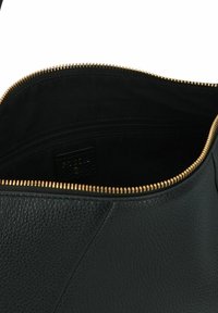 Borsa a tracolla in pelle nera testurizzata, aperta per mostrare l'interno in tessuto nero con una tasca con cerniera e chiusura con zip dorata.