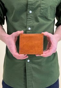 Brown leather wallet with visible stitching, presented in hands, featuring a smooth texture and flat rectangular shape.