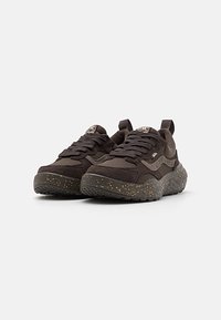 Sapatos atléticos pretos com um upper em tecido texturizado, língua acolchoada e entressola salpicada de preto e dourado. Apresenta uma sola de borracha robusta para maior aderência.