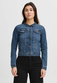 Chaqueta de mezclilla azul recortada con cierre de botones, dos bolsillos en el pecho y mangas largas. Presenta detalles de costura y un diseño de cuello clásico.