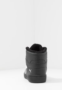 Black Puma high-top sneaker with white logo on heel, plush inner lining, displayed against a plain white background.