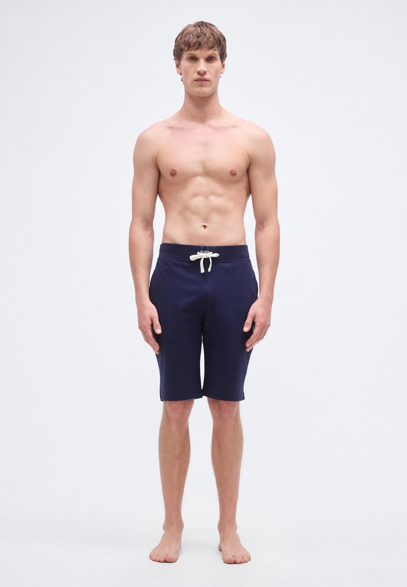 Μπλε μαγιό σορτς κατασκευασμένο από ελαφρύ υλικό με κορδόνι στη μέση, σχεδιασμό μέχρι το γόνατο και λεία υφή.