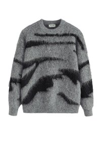 Pull gris en tricot avec une texture douce et duveteuse, présentant des rayures noires irrégulières et un col rond classique. Manches longues incluses.