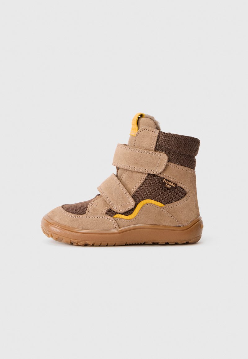 Brūna un smilškrāsa bērnu augstpapēžu kurpe ar dzelteniem akcentiem, Velcro siksnām un teksturētu zoli, novietota sānskatā uz baltā fona.