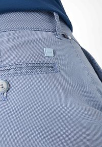 Blaue karierte Hose mit einer Vordertasche, Knopfverschluss und einem kleinen Etikett mit dem "Bion"-Logo. Der Stoff hat eine strukturierte Optik.
