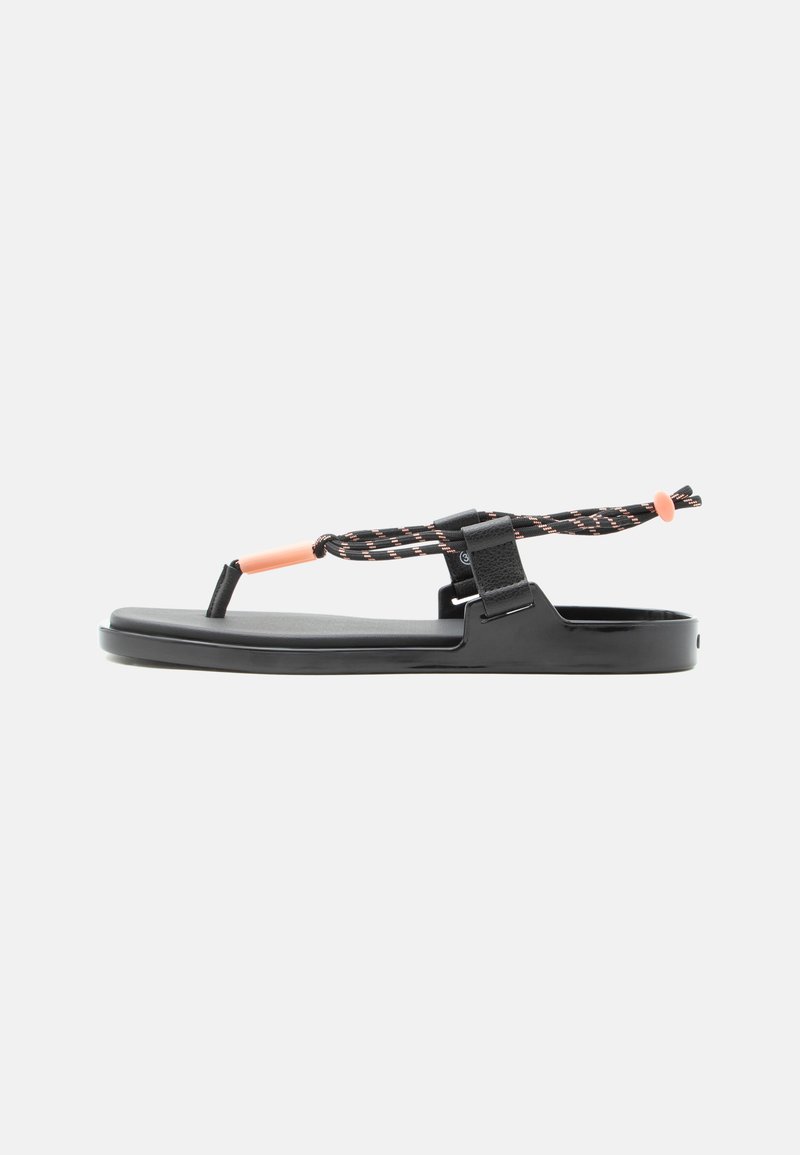 Black flat sandal with pink-accented adjustable cord straps and a toe loop, displayed on a white background.