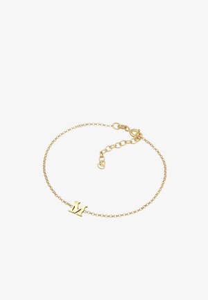 Kuldne kettkäevõru, millel on küljes "M" ripats, delikaatsed lingid ja reguleeritav pikkus koos klambri sulgemisega, mis tagab kindla sobivuse.