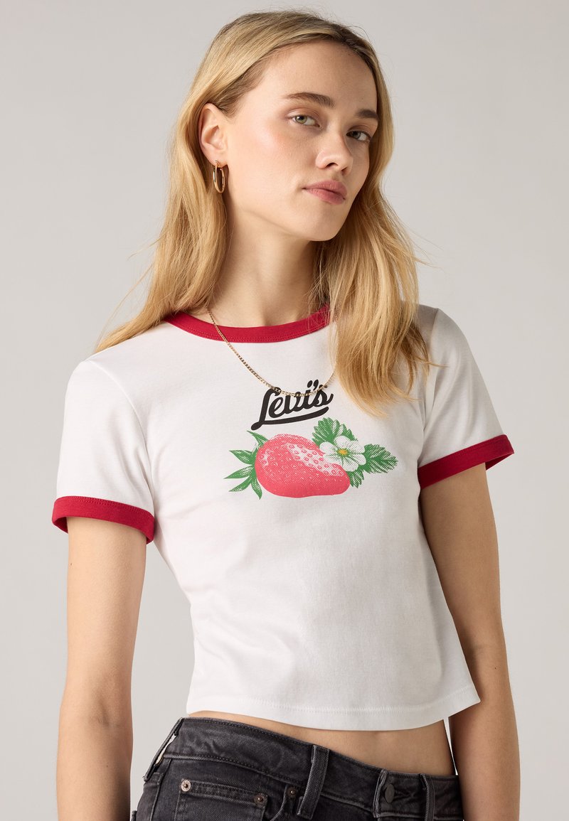 T-shirt blanc court avec des manches rouges, orné d'un motif imprimé de fraises et de fleurs avec le texte "Levi's" au-dessus de l'illustration.