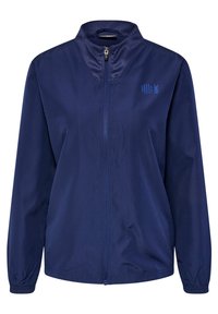 Mörkblå vindjacka med ståkrage, full dragkedja, elastiska manschetter och små logodetaljer på övre vänster sida.