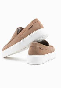 Tan nubukové slip-on boty s bílou gumovou podrážkou, zdobené prošívanými detaily a texturovanou stélkou pro komfort.