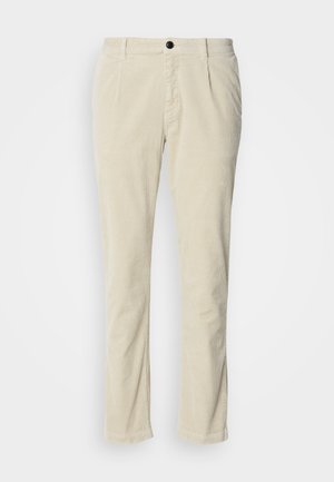 Calças de corduroy bege claro com corte reto, apresentando um único fecho de botão preto e uma textura de riscas subtil. Sem bolsos visíveis.