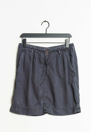 Tummanharmaa, keskipitkä hame, jossa on sileä pinta. Hameessa on kaksi etutaskua, nappi kiinnitys ja tikatut saumat.