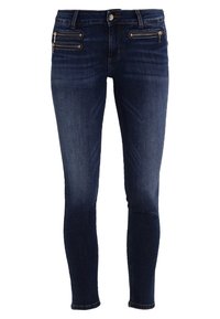 Jeans ajustados de mezclilla azul oscuro. Presentan dos bolsillos con cremallera en la parte frontal y un desgastado sutil. Pierna recta con detalles de costura.