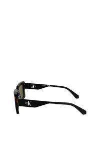 Lunettes de soleil rectangulaires noires avec une finition brillante, dotées de verres sombres et d'un logo 'CK' distinctif sur les branches.
