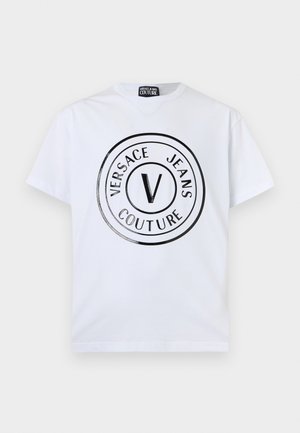 Wit T-shirt met korte mouwen, voorzien van een zwart rond Versace Jeans Couture-logo met de letter "V" in het midden aan de voorkant.