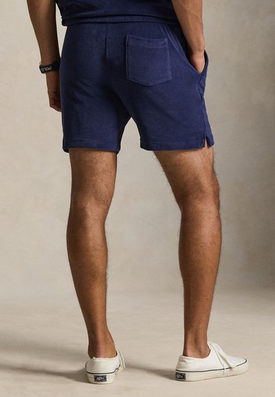 Σορτς από βαμβάκι σε ναυτικό μπλε χρώμα μέχρι το μέσο του μηρού, με πλαϊνές τσέπες και μια πίσω τσέπη με χιαστή ραφή. Ελαφριά υφή, με διακριτικό άνοιγμα στο τελείωμα.