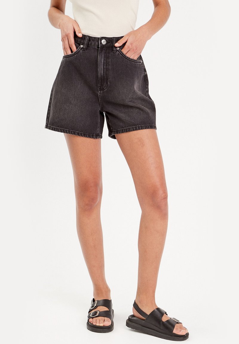 Zwarte denim shorts met een hoge taille, enkele knoopsluiting en vijf zakken. Losse pasvorm en een nette zoom met zichtbare stikdetails.