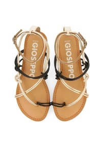 Hnědé ploché sandály s tenkými černými a béžovými pásky, s přezkami na kotnících, a jménem značky "GIOSEPPO" vytištěným na stélkách.