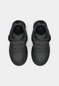 Svart sneakers med en jevn, teksturert finish. Har en rund tå, tre dekorative snører og en polstret krage. Logo synlig på innersålen.