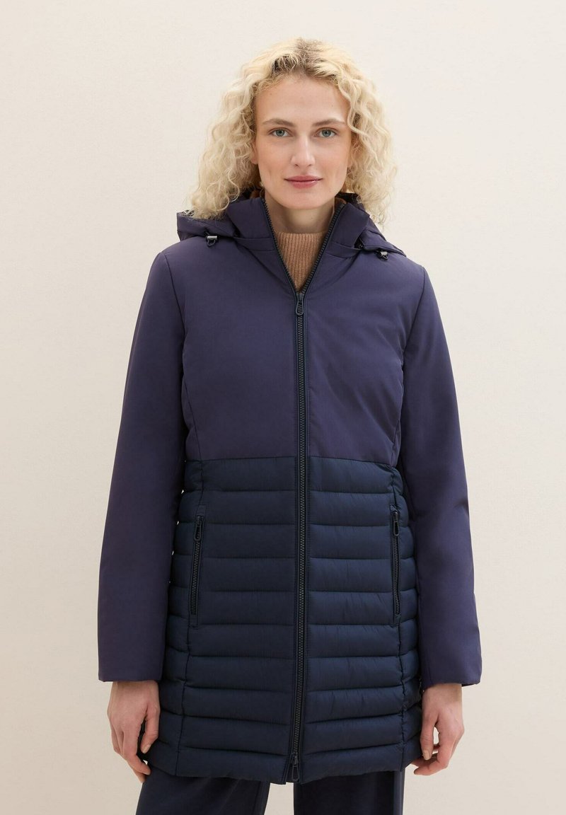 Granatowa kurtka puchowa z gładką górną częścią i pikowaną dolną. Posiada zamek błyskawiczny i boczne kieszenie. Teksturowane wykończenie.