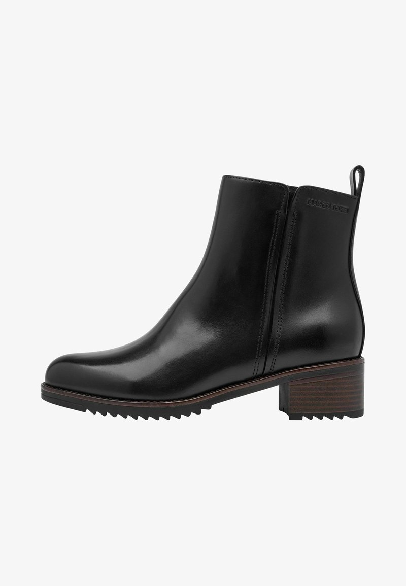 Bottine noire en cuir avec petit talon bloc, fermeture éclair latérale, languette arrière et semelle légèrement rainurée.