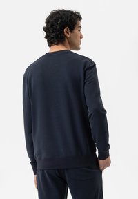 Navyblauw sweatshirt met lange mouwen, ribgebreide boorden en zoom. Gladde textuur, ontwerp met ronde hals. Gestyled met bijpassende broek.