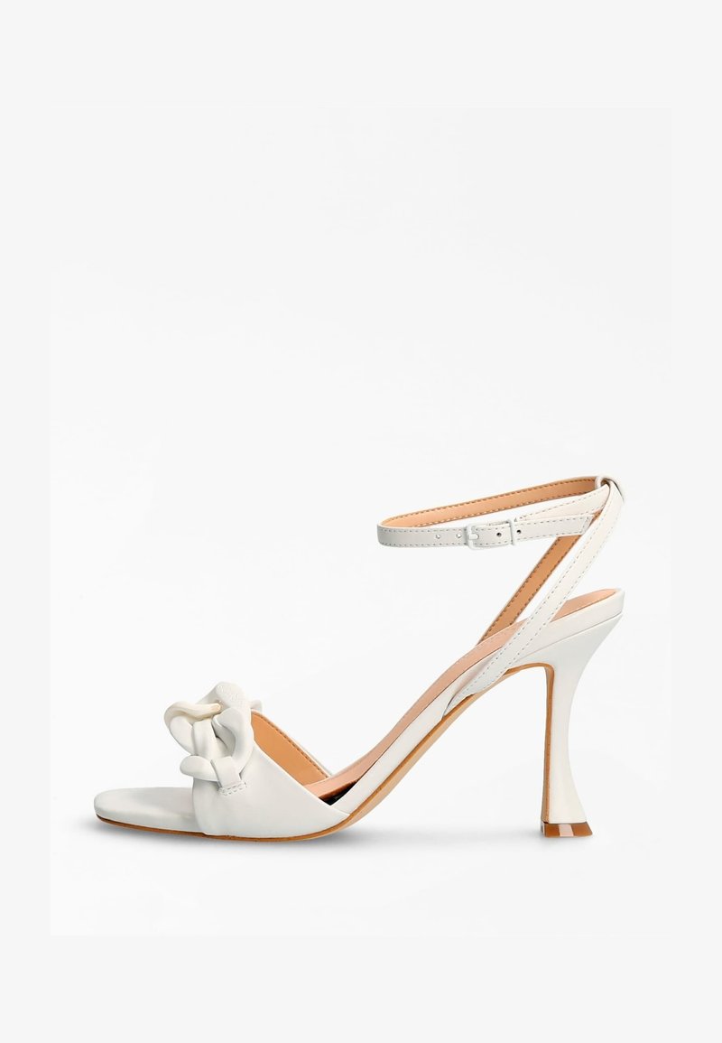 Sandale blanche à talon haut avec bout ouvert et bride à la cheville. Dotée d'un détail noué sur le dessus et d'un talon effilé. Finition en cuir lisse.