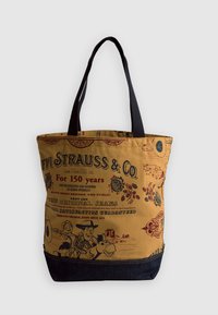 Beżowa torba na ramię z niebieskimi akcentami, z nadrukiem w stylu vintage, tekstem i kolorowymi postaciami z rysunków. Czarne paski na ramię.