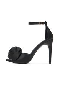 Czarne sandały na wysokim obcasie z zapięciem na kostkę i dużym detalem z tkaniny w kształcie róży z przodu, na otwartym palcu.