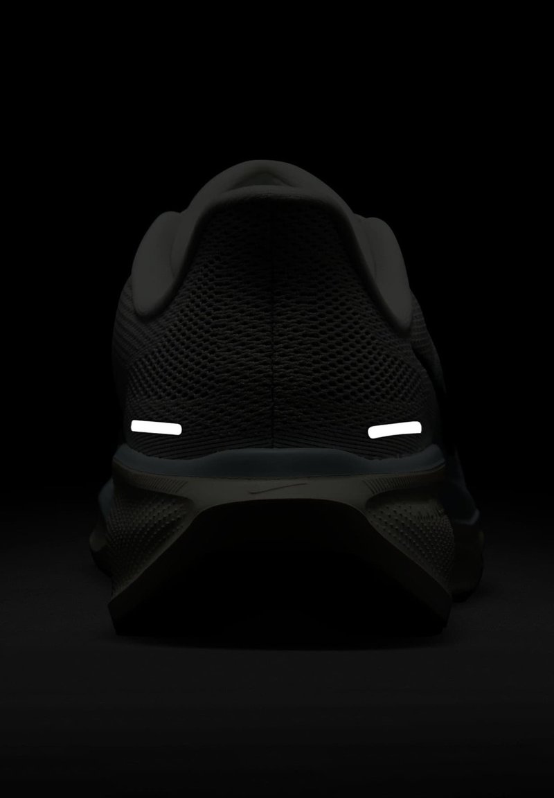 Scarpa da atletica nera con tomaia in mesh testurizzato, suola in gomma e dettagli riflettenti bianchi sul tallone.