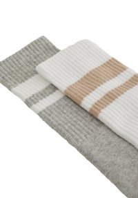 Twee paar sokken: één in lichtgrijs met strepen en een andere in wit met beige horizontale strepen, met een geribbelde textuur.