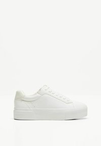 Baskets blanches avec une semelle en caoutchouc texturé, un dessus en cuir synthétique lisse, un bout arrondi et des détails de couture subtils. Design minimaliste.