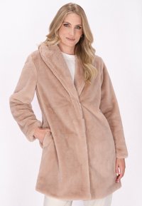 Palton din blană artificială bej, cu guler, mâneci lungi, buzunare laterale și lungime până la mijlocul coapsei. Textură moale și fără închizători vizibile.